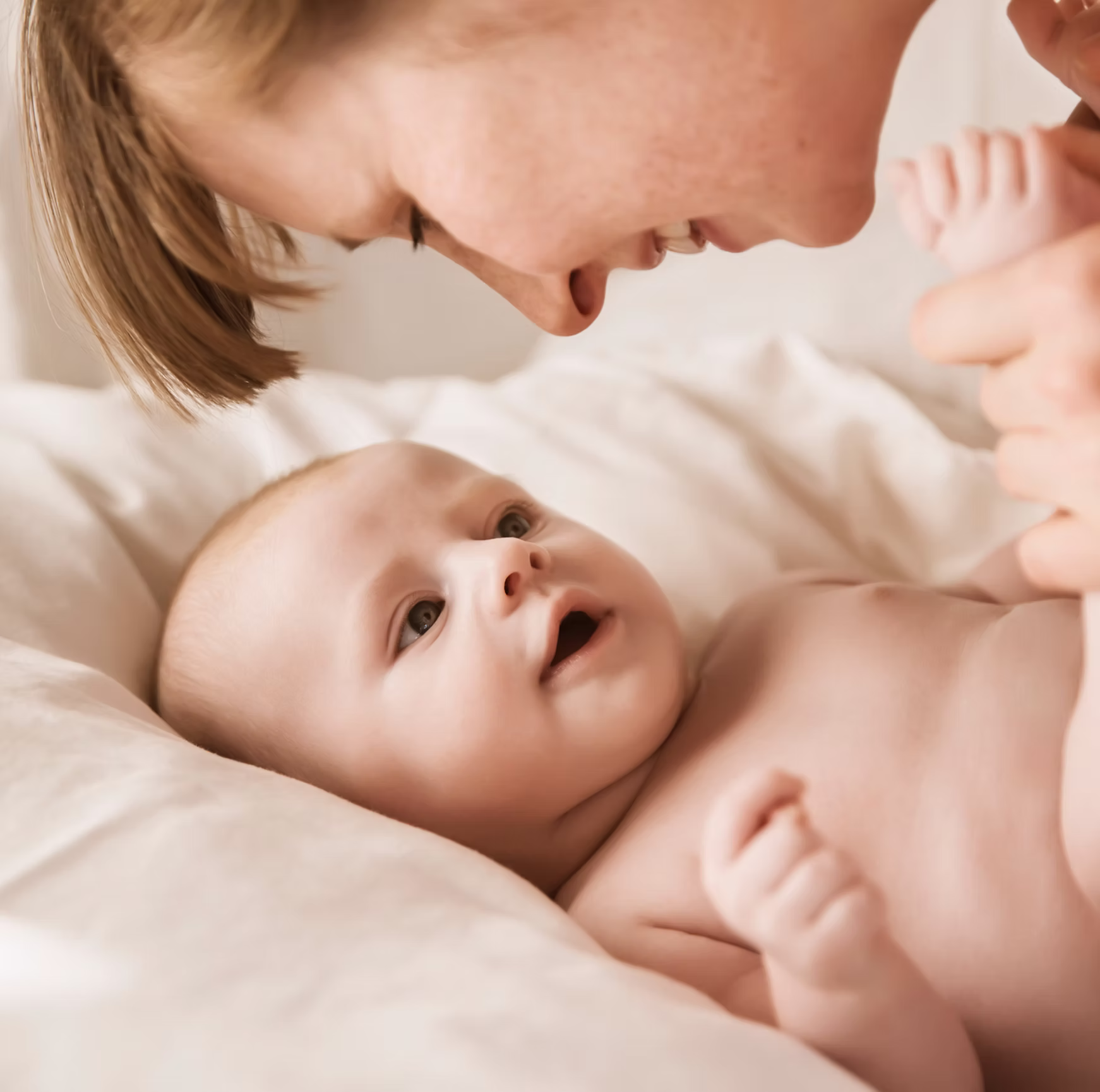 Mutter lächelt mit neugeborenem Baby